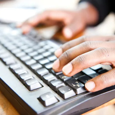 Person typing on a computer keyboard