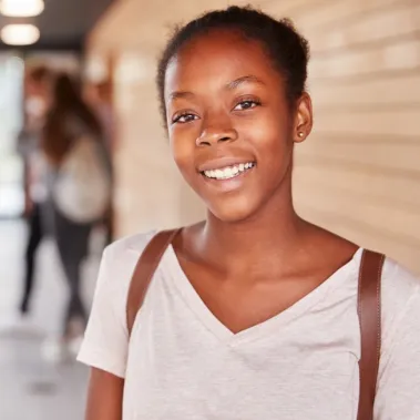 Girl with schoolbag smiling