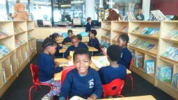 Children sitting in public library reading