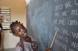 Child reading out loud at chalkboard