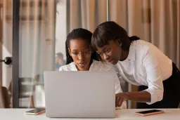 Two women sitting at a laptop